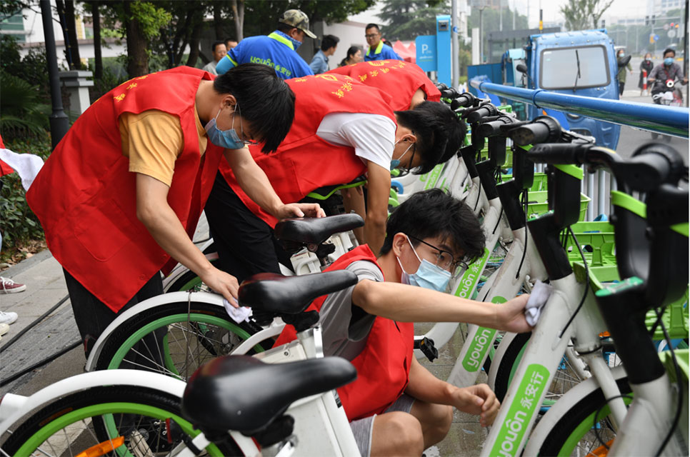 世界無車日，志愿者走上街頭擦亮共享助力車